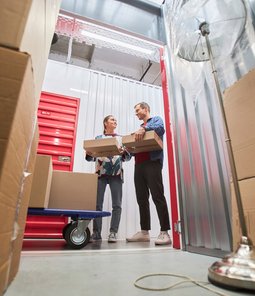 Two people putting things in storage